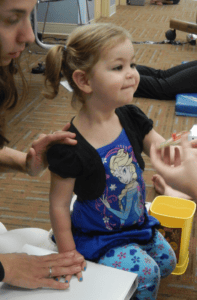 A little girl participating in pediatric therapy at an early learning center.