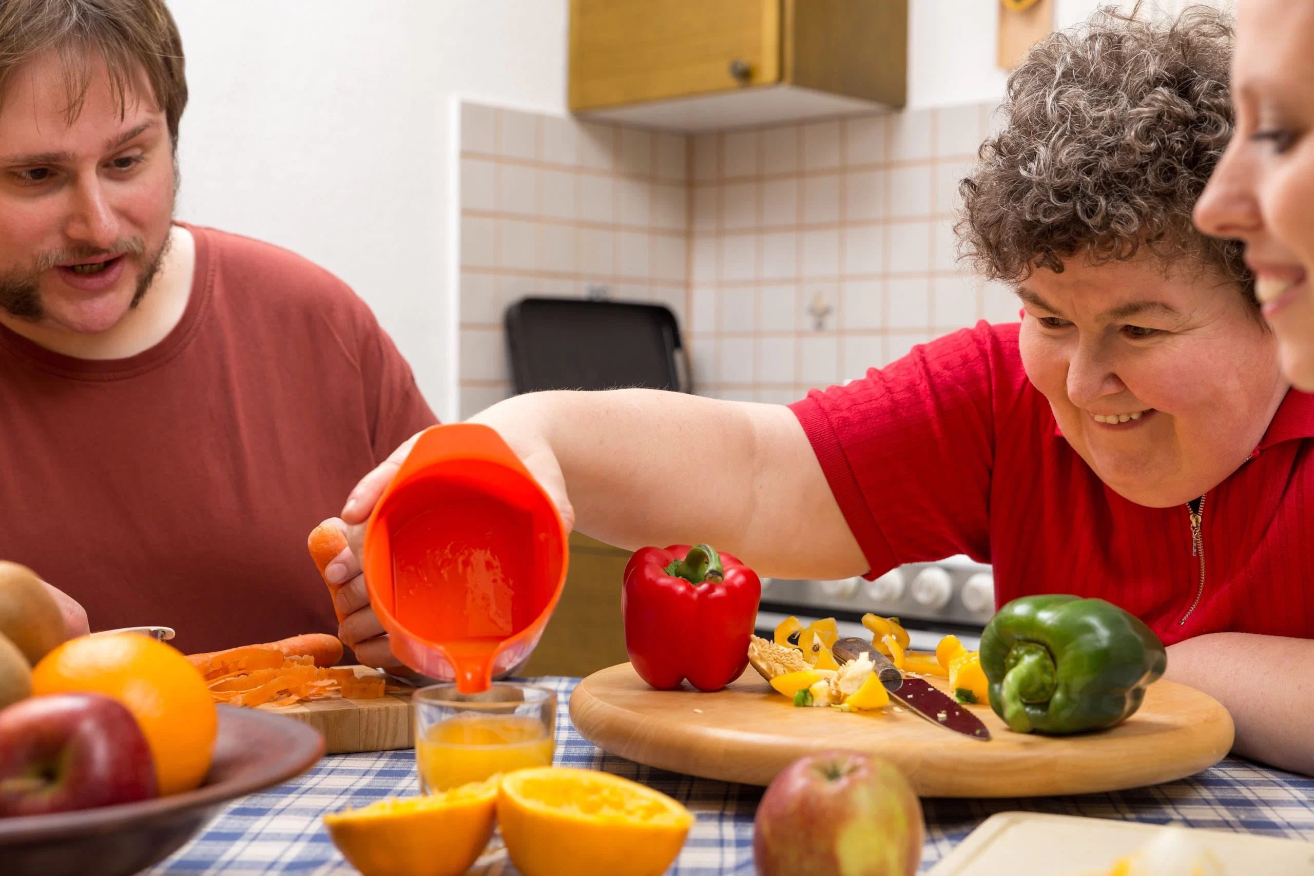 A man prepares a bowl of fruit at an early learning center.