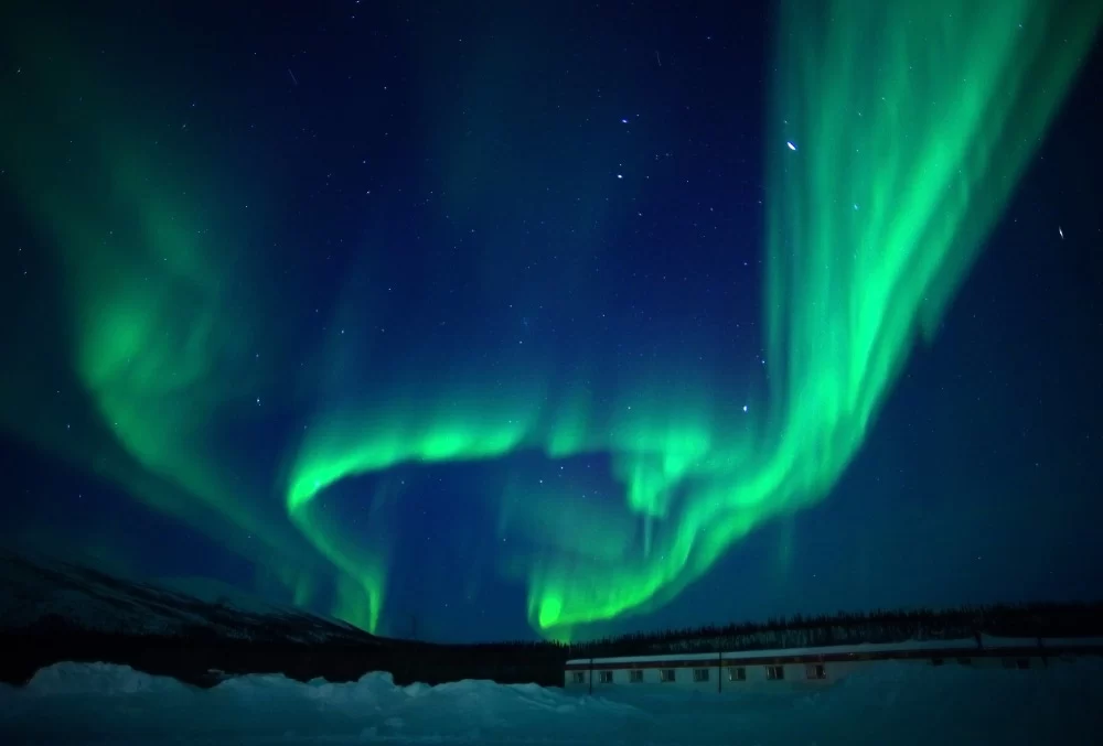 The aurora borealis illuminates the night sky.