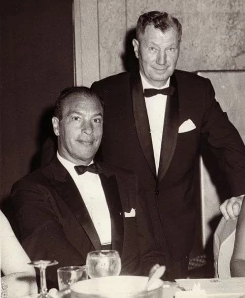 Black and white photo of a couple in tuxedos.