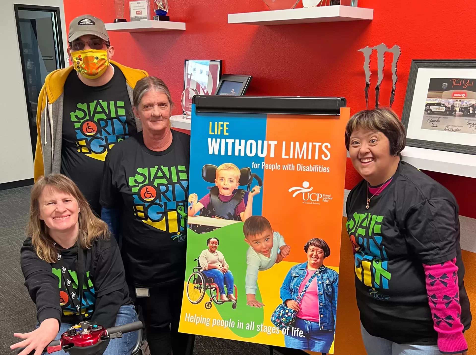 A group of people posing in front of a sign that says life without limits, representing an early learning center.