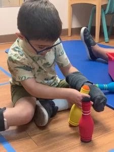 A young boy engaging in pediatric therapy at an early learning center.