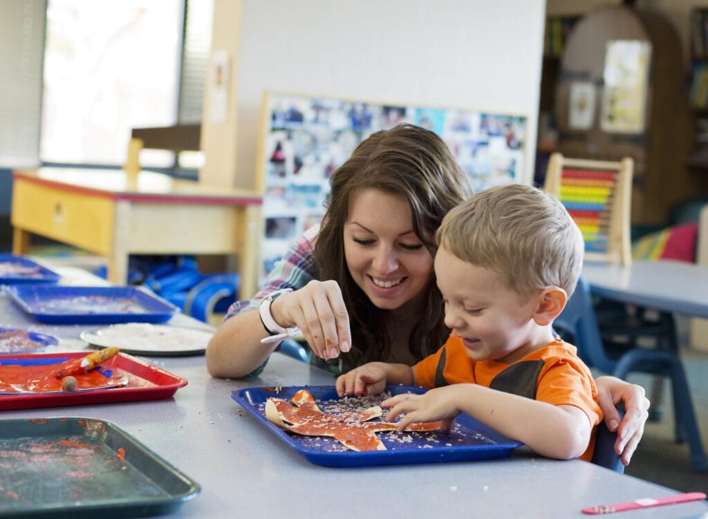 A woman and a child engaged in crafts at the Early Learning Center.