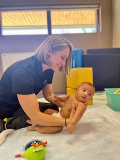 A woman is playing with a baby at the Early Learning Center.